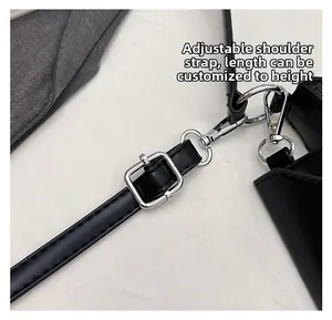 Detail of adjustable black leather shoulder strap with silver metal buckle and lobster clasp