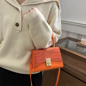 Chic orange faux crocodile embossed square handbag with golden twist lock on model