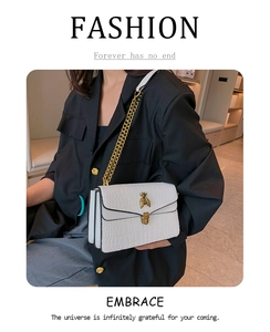 Détail du sac à bandoulière blanc motif crocodile avec fermoir abeille doré et chaîne