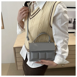 Detail of grey quilted handbag with chocolate block texture and elegant gold hardware