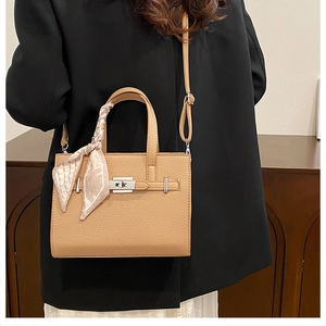 Détail du sac beige grainé avec fermoir argenté et accessoire foulard en soie décoratif