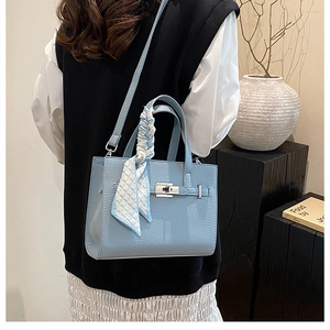 Détail du sac cabas bleu clair à motif litchi avec fermoir argenté et foulard en soie