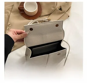 Dettaglio interno della borsa in pelle beige con chiusure magnetiche e scomparto ampio