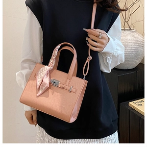 Détail du sac cabas rose en cuir grainé avec foulard sur l'anse et fermoir métal