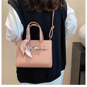 Détail du sac cabas rose texture litchi avec foulard en soie et fermoir argenté
