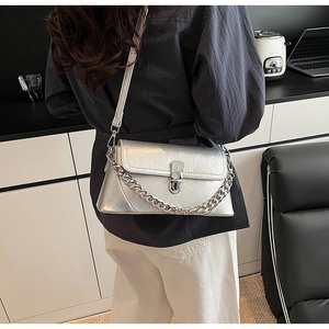 Détail du sac à chaîne argenté montrant le cuir métallisé et la grosse chaîne en métal