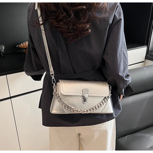 Détail d'un sac bandoulière argenté effet froissé avec chaîne et boucle métallique