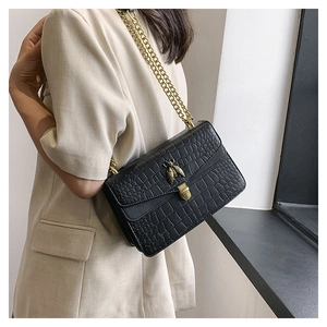 Détail du sac à bandoulière noir motif crocodile avec boucle abeille dorée et chaîne