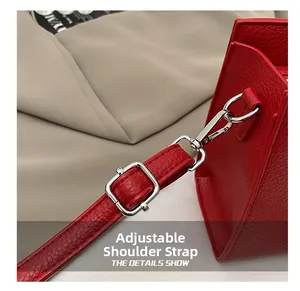 Détail du cabas rouge en cuir grainé avec bandoulière réglable et fermoir argenté brillant