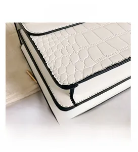 Détail du cuir blanc embossé crocodile et de la structure à soufflets multicouches