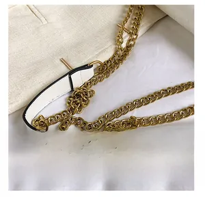 Détail de la bandoulière en cuir blanc et chaîne en métal doré pour sac à main
