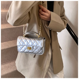 Silver patent leather crossbody bag with quilted texture and gold chain strap