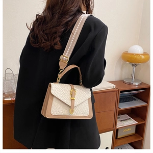 Detail of the woven texture and retro ethnic embroidered wide shoulder strap on the bag