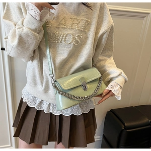 Détail du sac bandoulière vert clair brillant avec chaîne argentée et fermoir