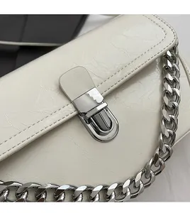 Détail du sac à bandoulière matelassé blanc cassé avec fermoir argenté et chaîne épaisse