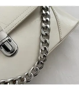 Détail du sac en cuir blanc crème avec chaîne argentée et fermoir métallique poli