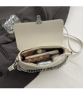 Détails de l'intérieur d'un sac crème montrant les compartiments et la poche zippée