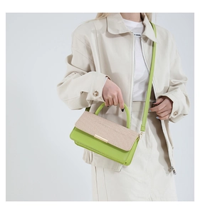 Détail du sac bandoulière vert et beige avec texture tissée et boucle en métal doré