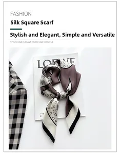 Vue détaillée d'un foulard en soie à motifs de maillons marron sur un magazine blanc