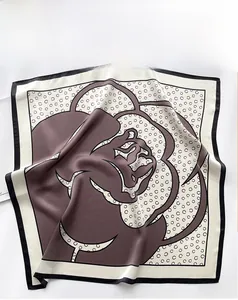Détail d'un foulard en soie avec motifs floraux et pois de couleur marron et crème