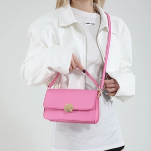 Pink leather shoulder bag with a large gold circular buckle for women's spring fashion