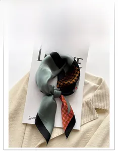 Close-up of houndstooth silk scarf on a magazine and ribbed knit sweater texture