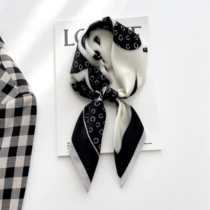 Élégant foulard en soie noir et blanc avec motif en C sur un magazine de mode