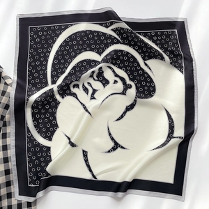 Détail macro d'un foulard en soie noir et blanc avec motif élégant de fleur de camélia