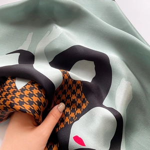 Detail of silk scarf showing houndstooth patterns and abstract art with a glossy finish