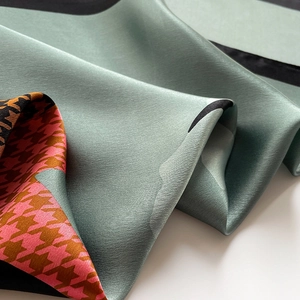 Detail view of premium silk scarf showing hounds-tooth pattern and soft satin texture