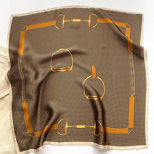 Detail of silk scarf showing equestrian horse bit print and houndstooth pattern texture