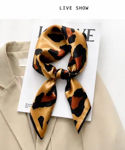 Detail of leopard print silk scarf knotted on a blazer for a high-fashion elegant look