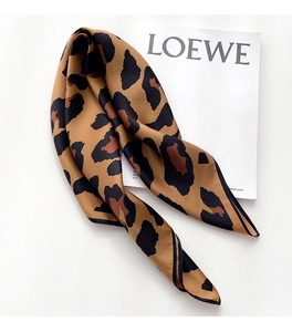 Detailed view of leopard print silk scarf with fine black stitching and satin texture