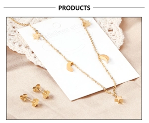 Détail de l'ensemble collier et boucles d'oreilles étoile en acier doré sur dentelle