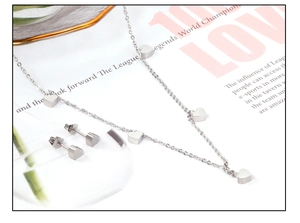 Vue détaillée de la parure en acier inoxydable argenté avec pendentifs et boucles d'oreilles