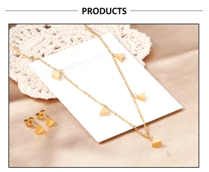 Vue détaillée de la parure en acier doré avec cinq pendentifs triangulaires et boucles