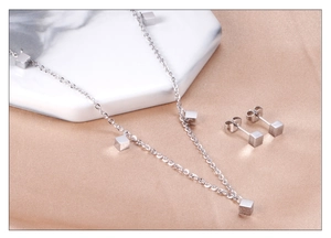 Vue détaillée d'une parure bijoux minimaliste argentée avec pendentifs carrés