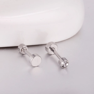 Macro shot of silver stainless steel dumbbell earrings with clear cubic zirconia stone