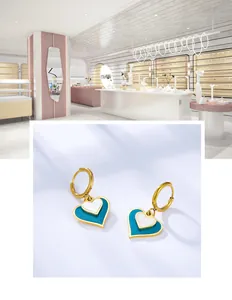Detailed macro of gold heart earrings featuring blue and white double-layered enamel