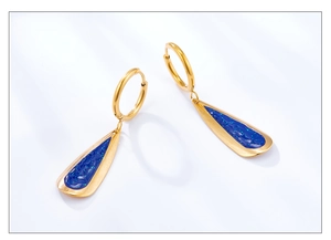 Close-up of golden hoop earrings with teardrop blue enamel and fine glitter details