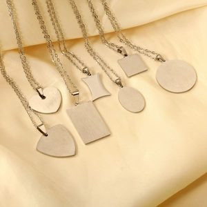 Collection of seven minimalist stainless steel geometric pendants on silk background