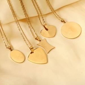 Collection of minimalist gold geometric pendants on satin fabric with brushed finish