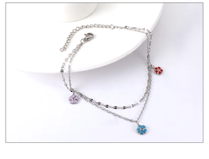 Detail of double-layer stainless steel anklet with colorful enamel flower pendants