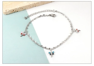 Detail of silver double-layered anklet featuring three colorful enamel dragonfly charms