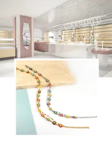 Detailed shot of gold and silver anklets featuring colorful daisy charms in vivid enamel