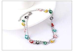 Close-up of colorful enamel evil eye charms on a stainless steel double-layer anklet