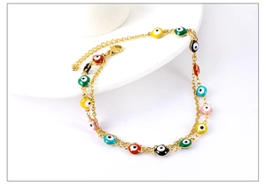 Detail of double-layer gold anklet with colorful evil eye beads and adjustable clasp