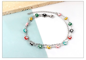 Detail of double-layer silver anklet with colorful enamel evil eye beads and lobster clasp