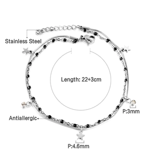 Detail eines silbernen doppellagigen Fußkettchens mit Sternanhänger und schwarzen Perlen