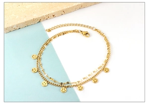 Detailed shot of double-layer gold anklet with eight smiling face charms and lobster clasp